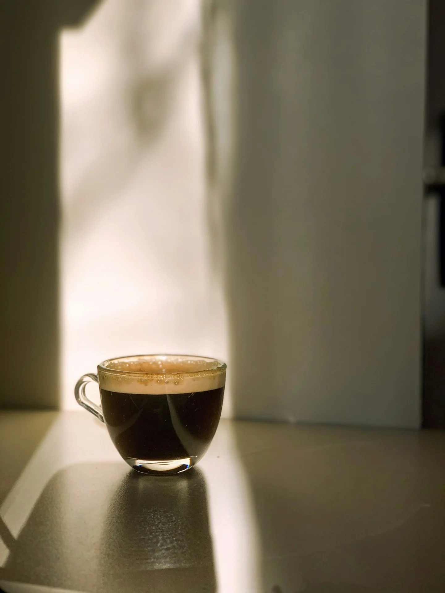 A small cup of coffee in morning window light