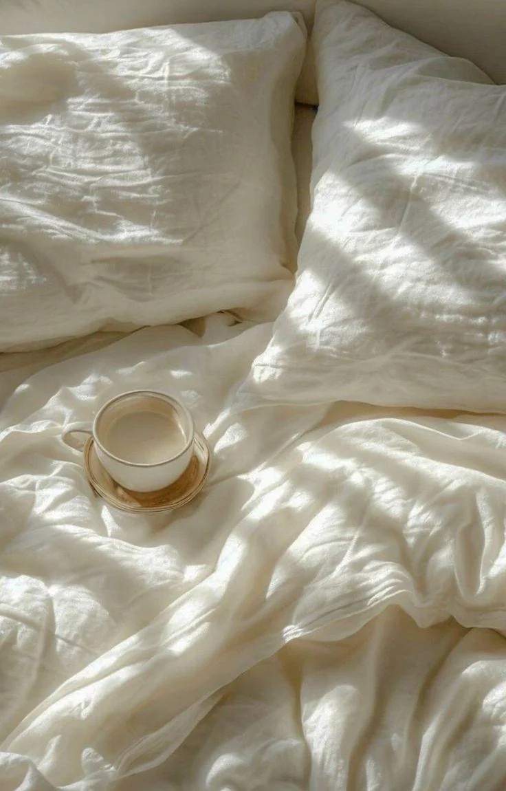 Rumpled linen bedding in morning light