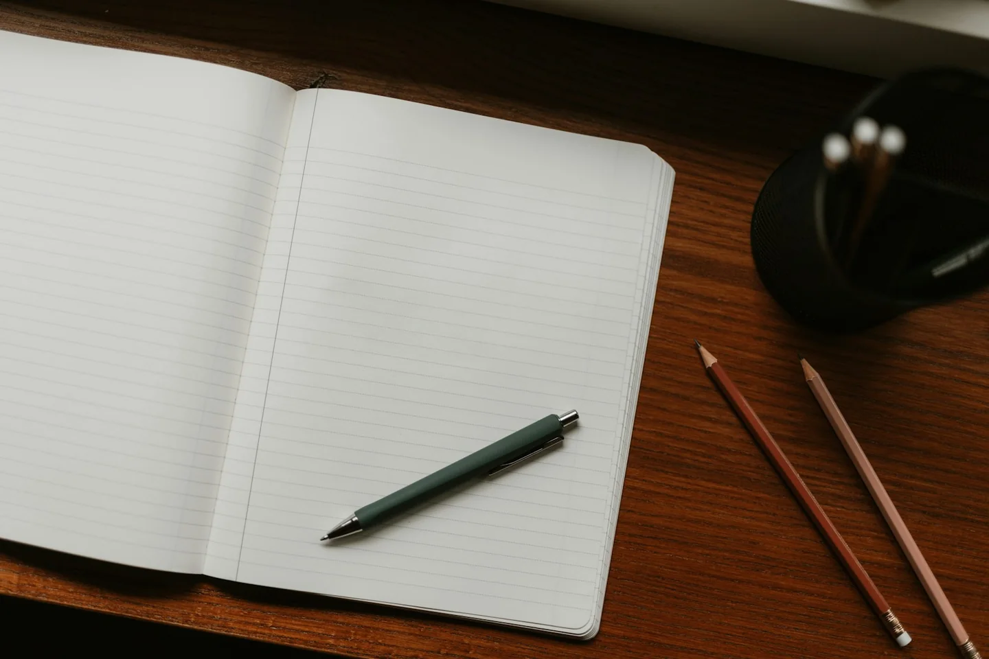 An open blank notebook with a pen beside it