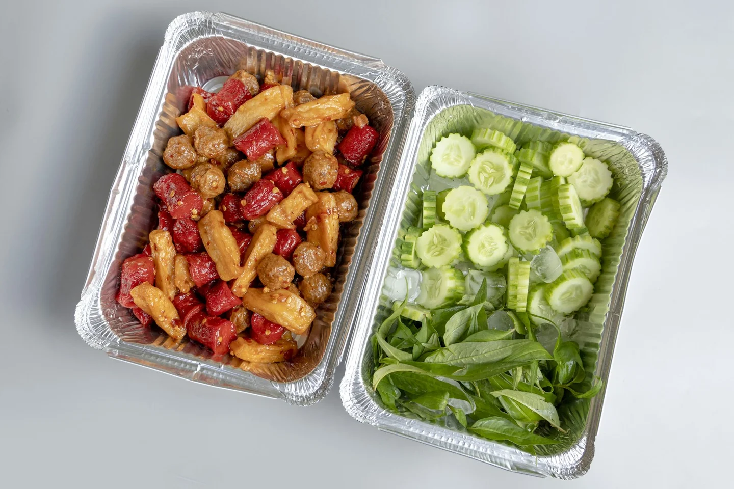 Prepared pasta and cucumber packed in two food containers
