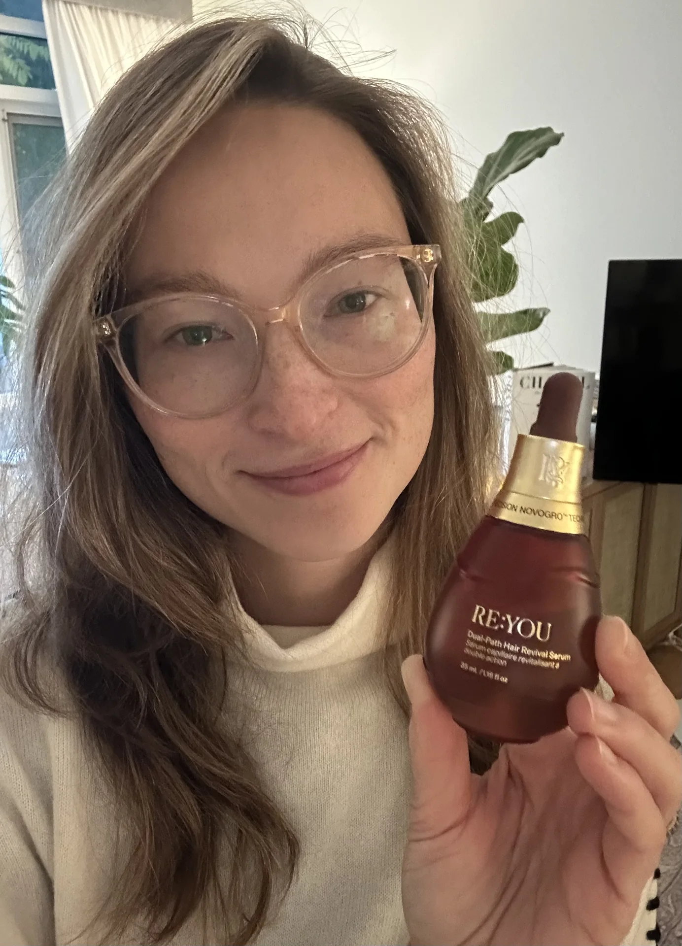 Nicole holding the RE:YOU Dual-Path Hair Revival Serum bottle